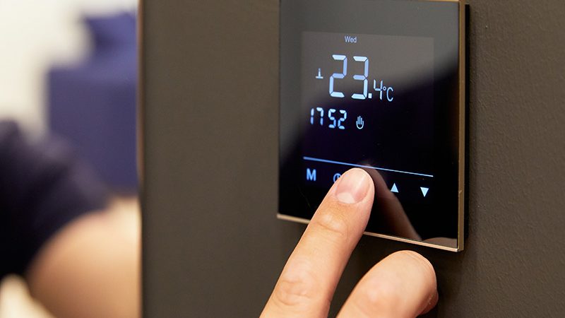 thermostat-chauffage Une personne en train de modifier un thermostat de chauffage